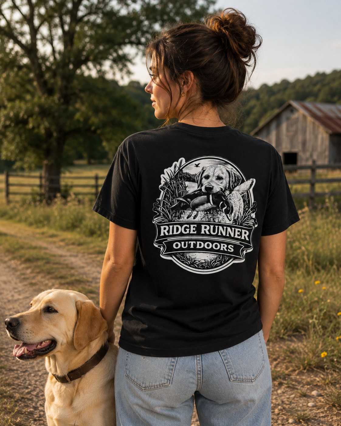 Woman wearing a 'Ridge Runner Outdoors' t-shirt with a dog graphic, standing outdoors with a dog.